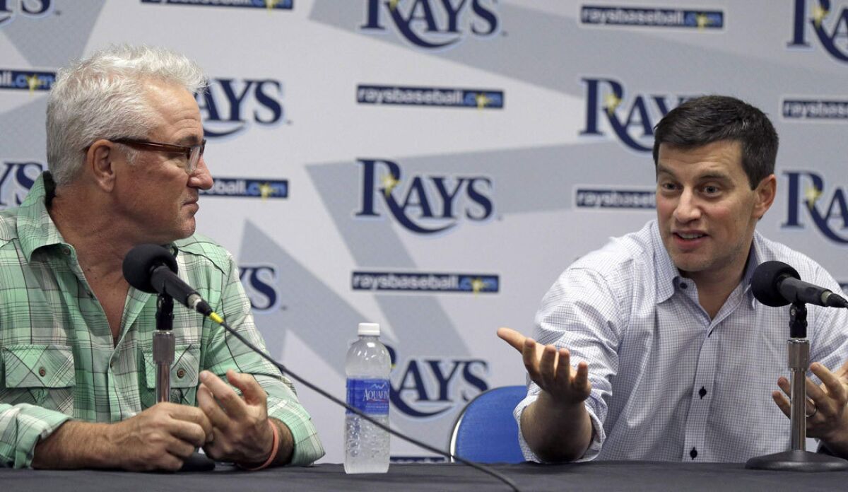Andrew Friedman, right, sits with Tampa Bay manager Joe Maddon during the 2013 season.