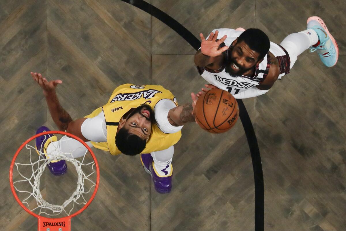 Nets guard Kyrie Irving lofts a shot over Lakers forward Anthony Davis during a game on Jan. 23, 2020, at Barclays Center in Brooklyn.