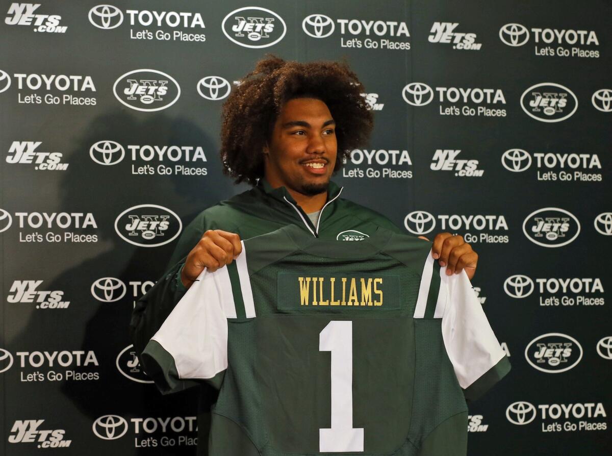 Former USC Trojan Leonard Williams holds up a New York Jets jersey as he is introduced to the media on Friday.
