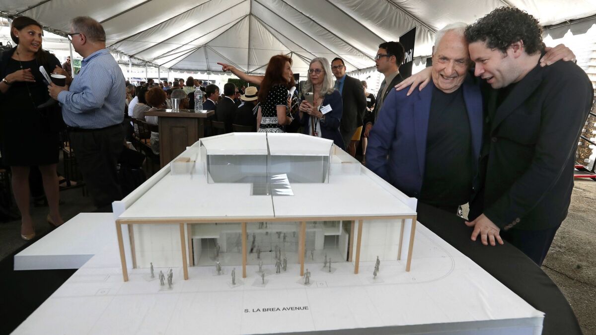 At right, Gustavo Dudamel embraces architect Frank Gehry as they view Gehry's model for the new YOLA Center.