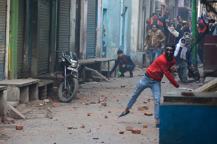 Demonstrators throw stones during a protest against India's citizenship law in Meerut on Dec. 20.