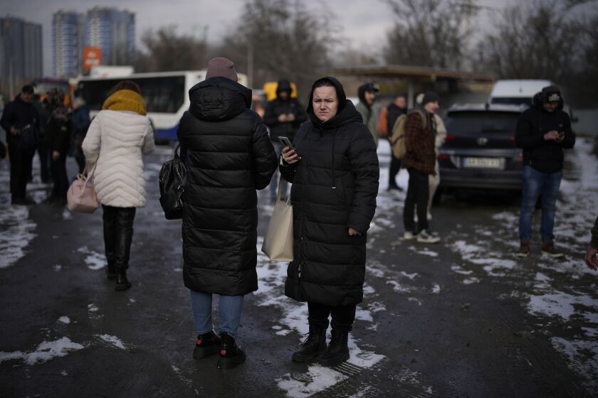 Gente esperando en una calle cortada por la policía tras un ataque de cohete en Kiev, Ucrania, el jueves 26 de enero de 2023. (AP Foto/Daniel Cole)