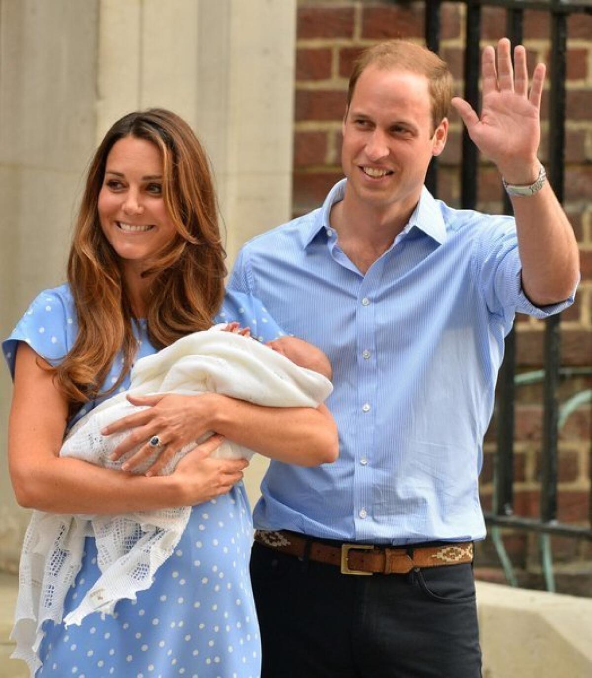The Duchess of Cambridge and Prince William taking home their baby, swaddled in two blankets.