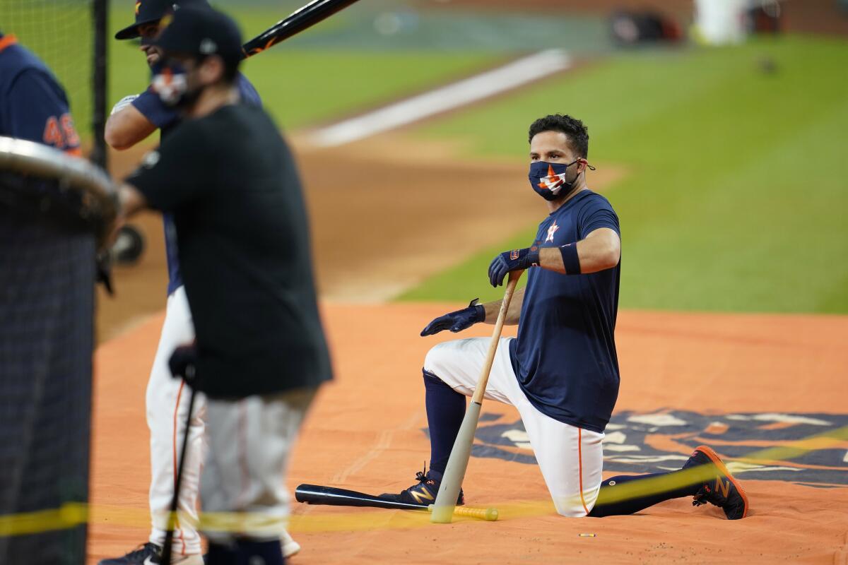 Houston Astros second baseman Jose Altuve wears as mask as he waits to hit during batting practice.
