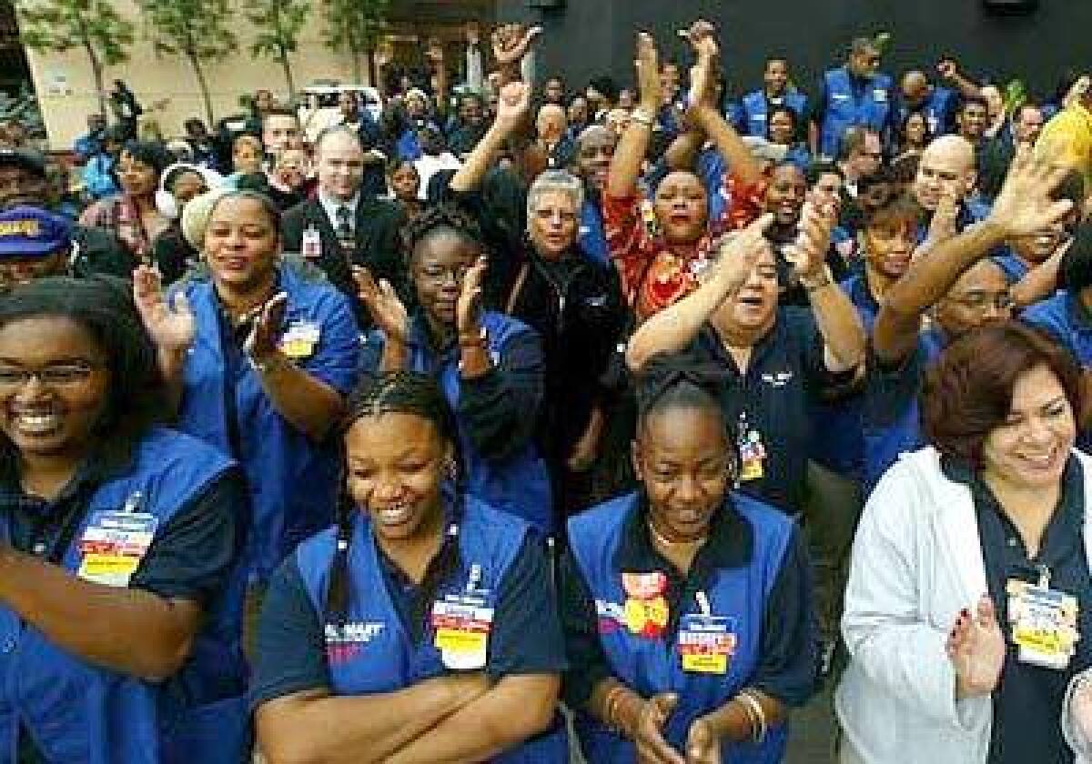 Wal-Mart employees cheer as they await the grand opening of the Baldwin Hills Crenshaw Plaza store on January 22, 2003.