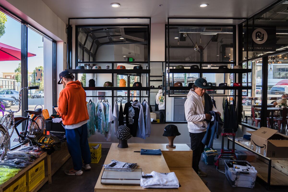 Owner Kwa Nguyen, left, inside his The Fresh Yard clothing shop at Market on 8th in National City.