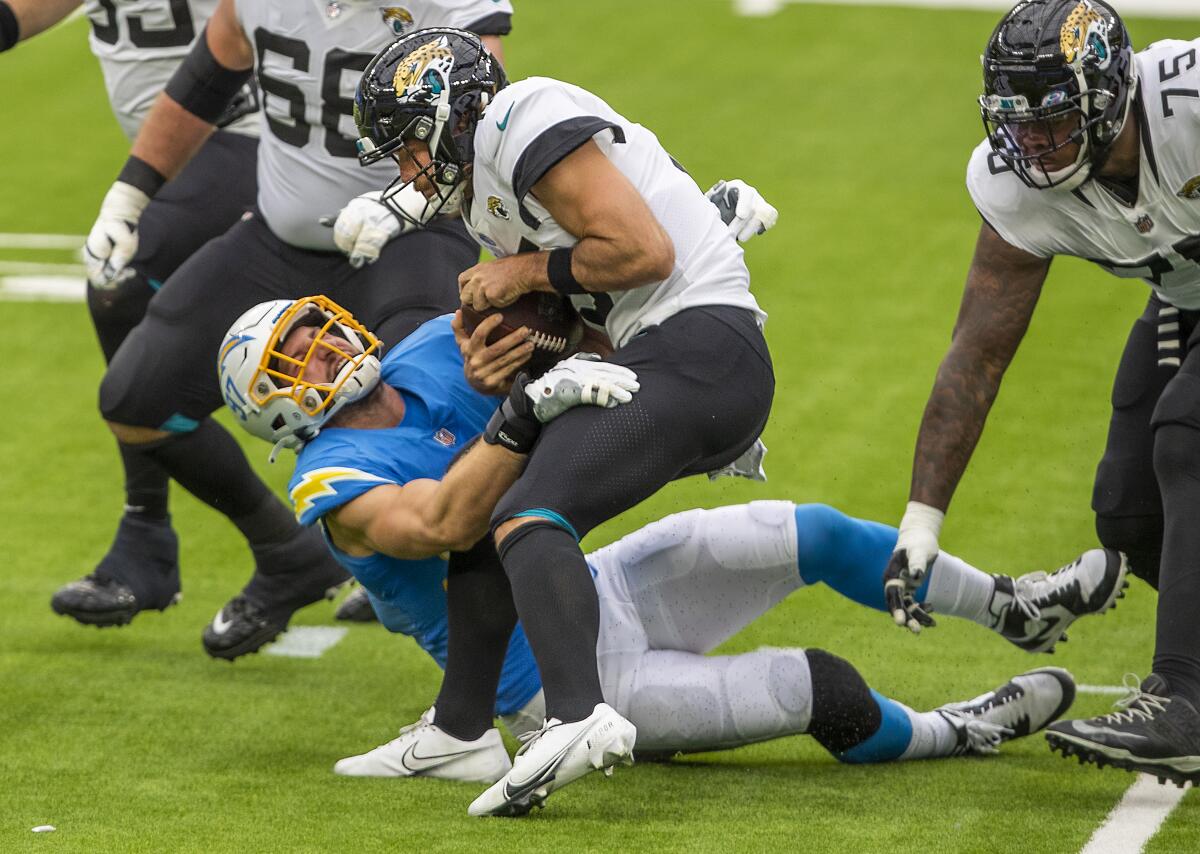 Chargers defensive end Joey Bosa assists in sacking Jaguars quarterback Gardner Minshew at SoFi Stadium.