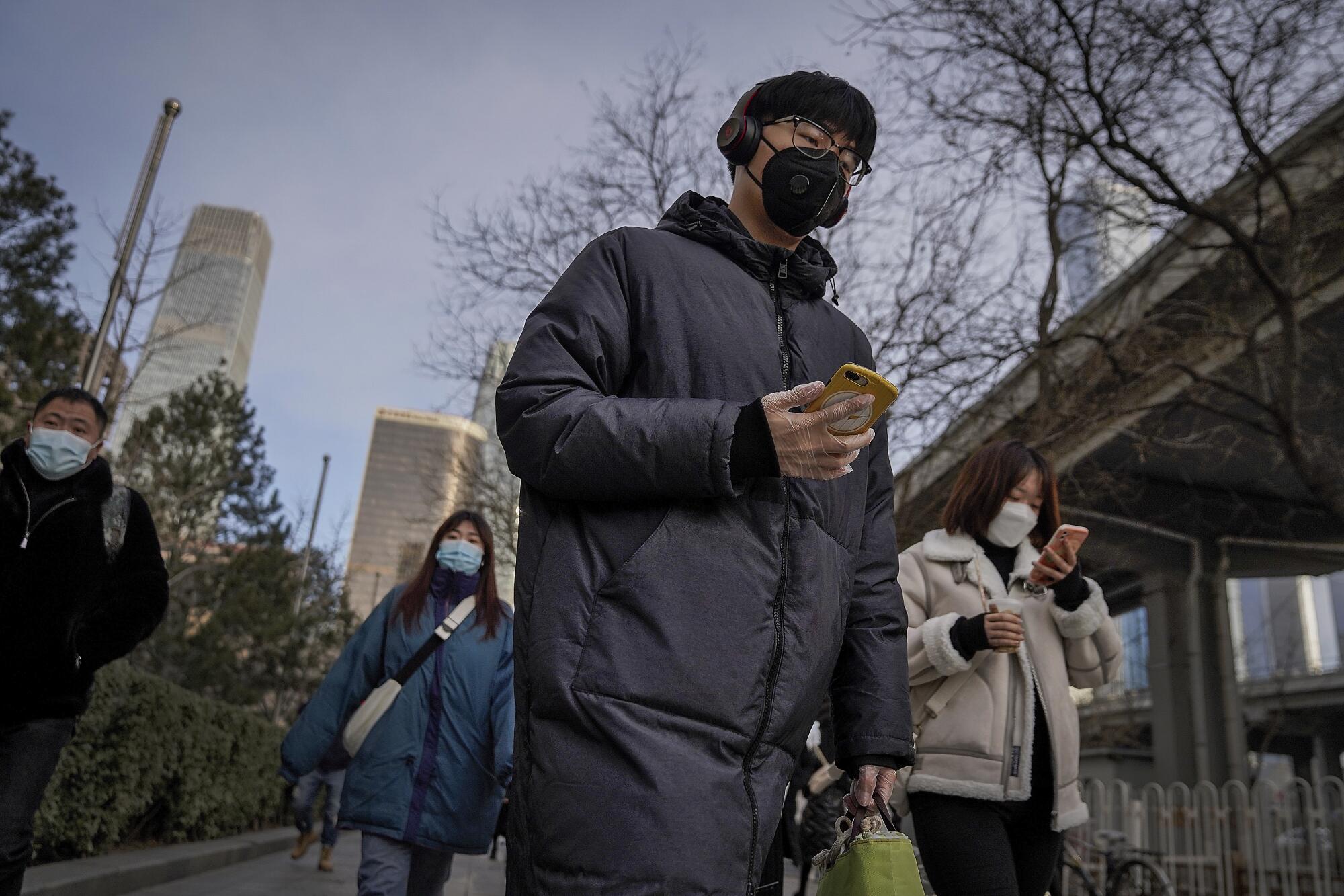 A man wearing a mask heads to work in Beijing.