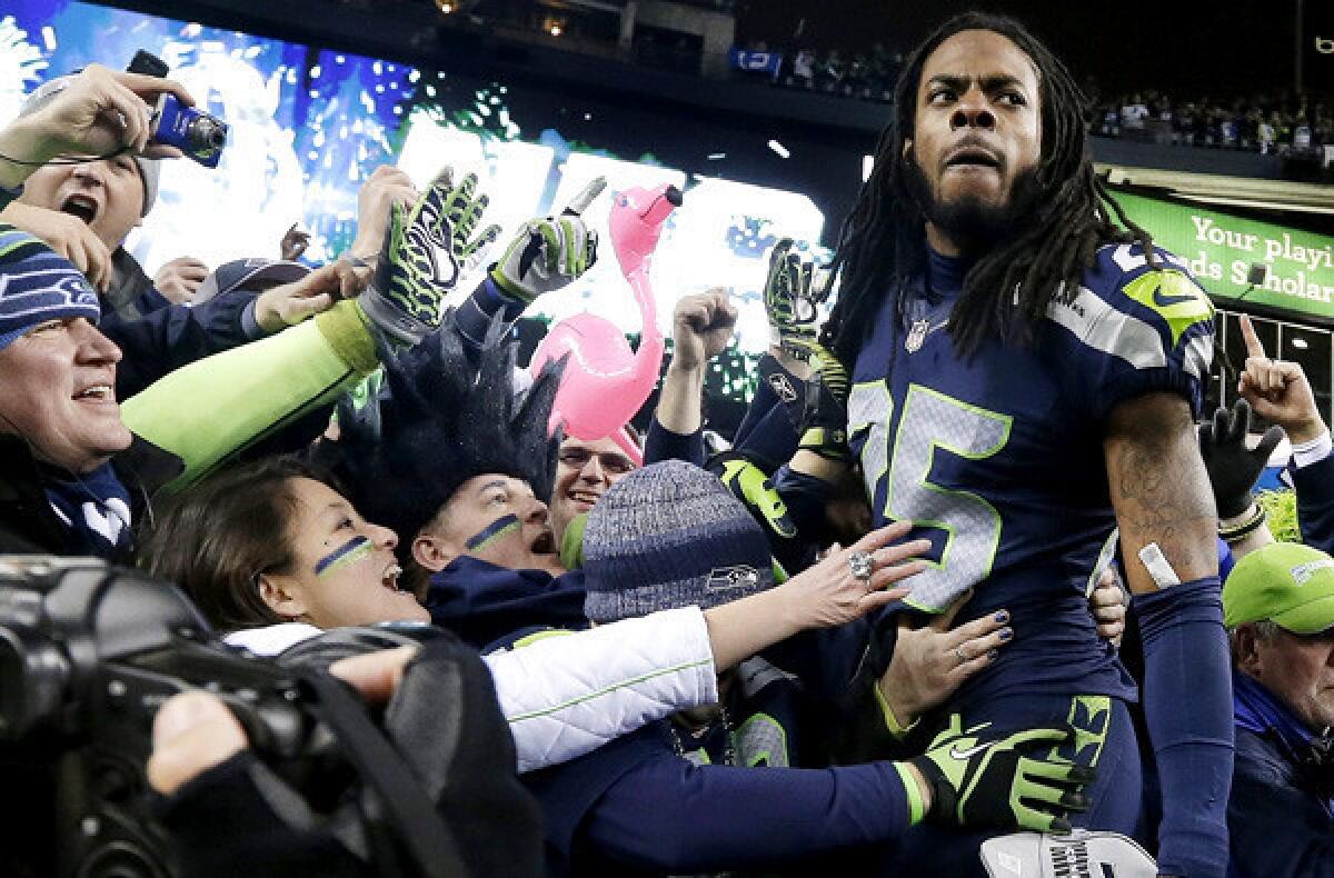 Seahawks cornerback Richard Sherman celebrates with fans after after winning the NFC championship game on Sunday in Seattle.