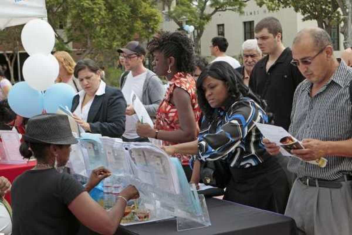 People look for jobs at the Los Angeles World Airports booth during a job fair at Los Angeles City College.