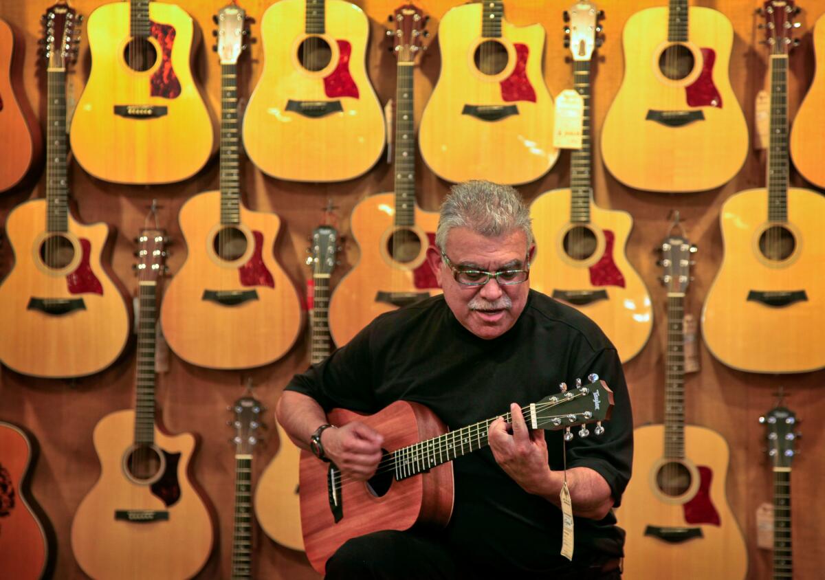 Noel Dickson plays a guitar at McCabe's Guitar Shop.