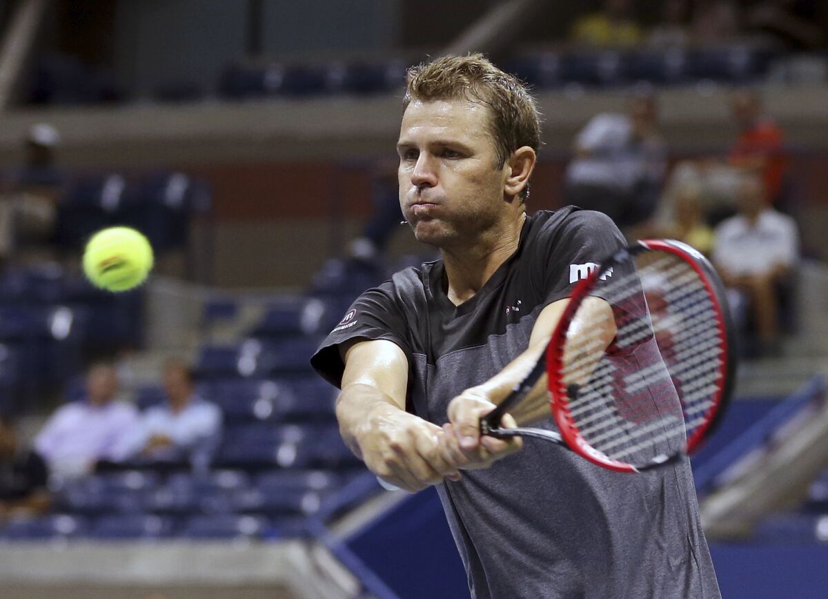 Mardy Fish hits a return during a 2015 exhibition doubles match at the U.S. Open 