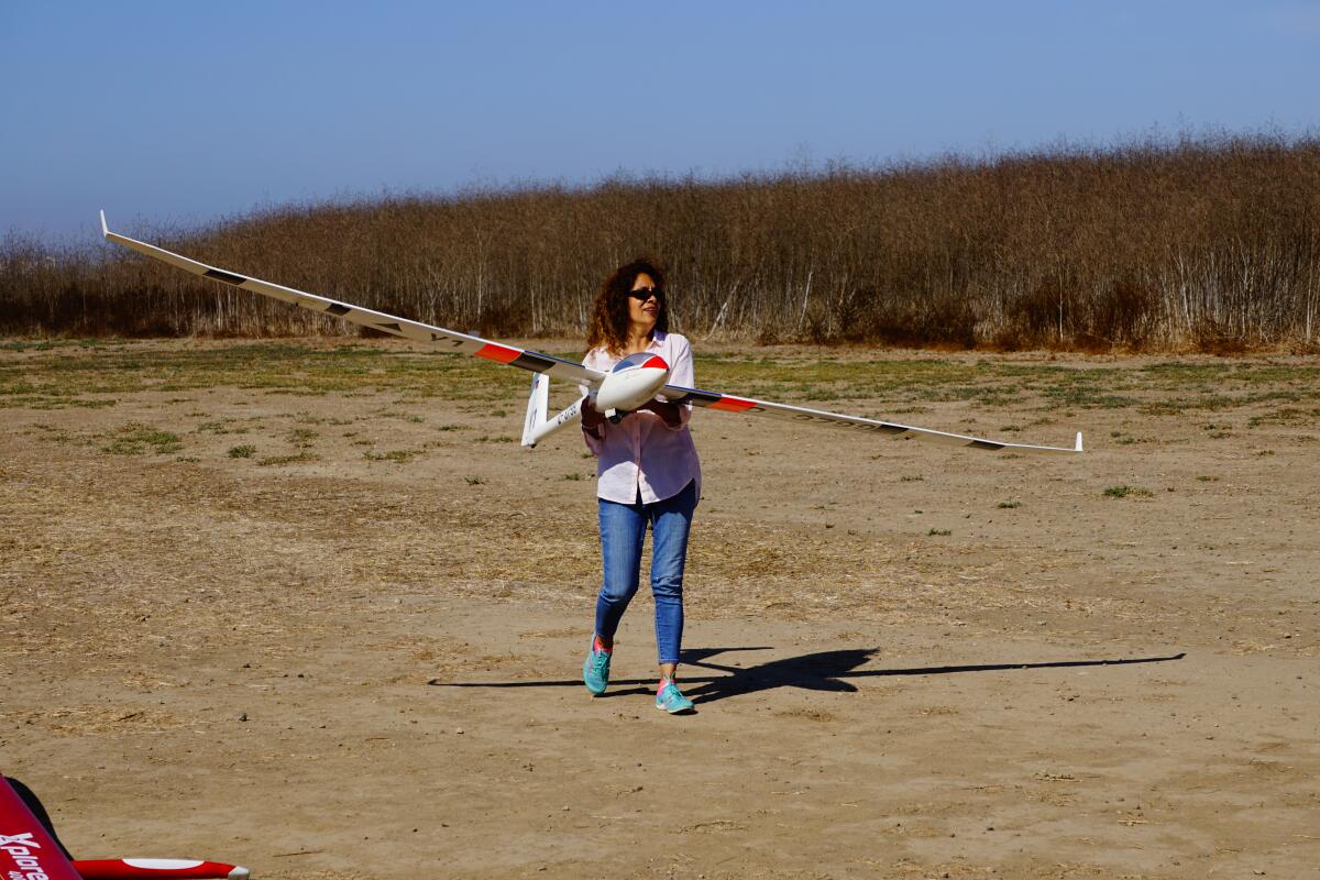 A woman holds a glider during a Harbor Soaring Society open house in 2019. 