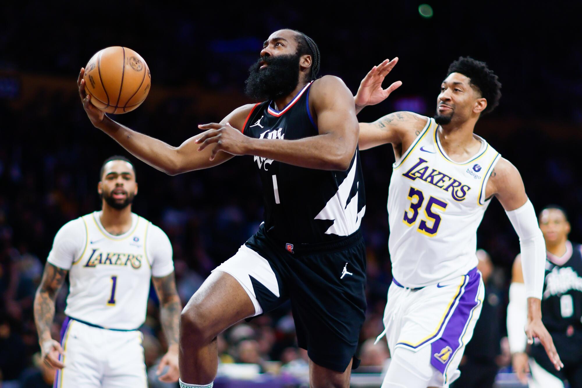 Clippers guard James Harden (No. 1) drives to the basket past Lakers forward Christian Wood.