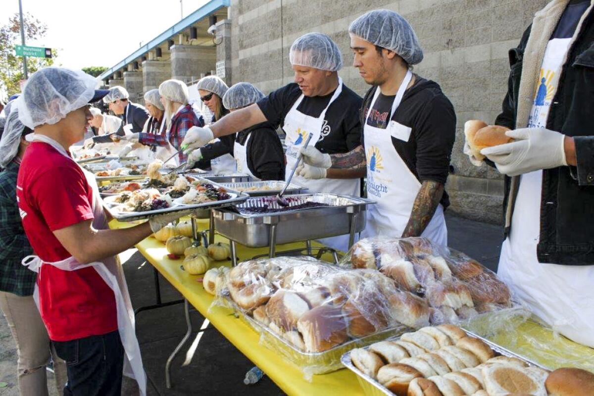 Volunteers with the Midnight Mission serve up food