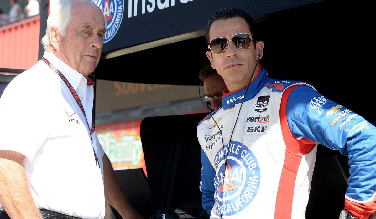 Team owner Roger Penske and IndyCar driver Helio Castroneves chat during a practice session Friday at Auto Club Speedway in Fontana.