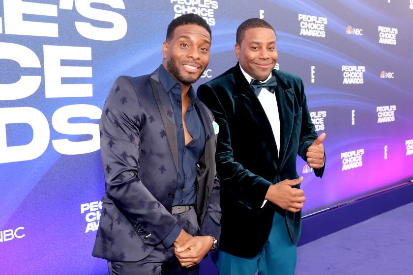 Kel Mitchell and Kenan Thompson pose on a purple carpet at an awards show