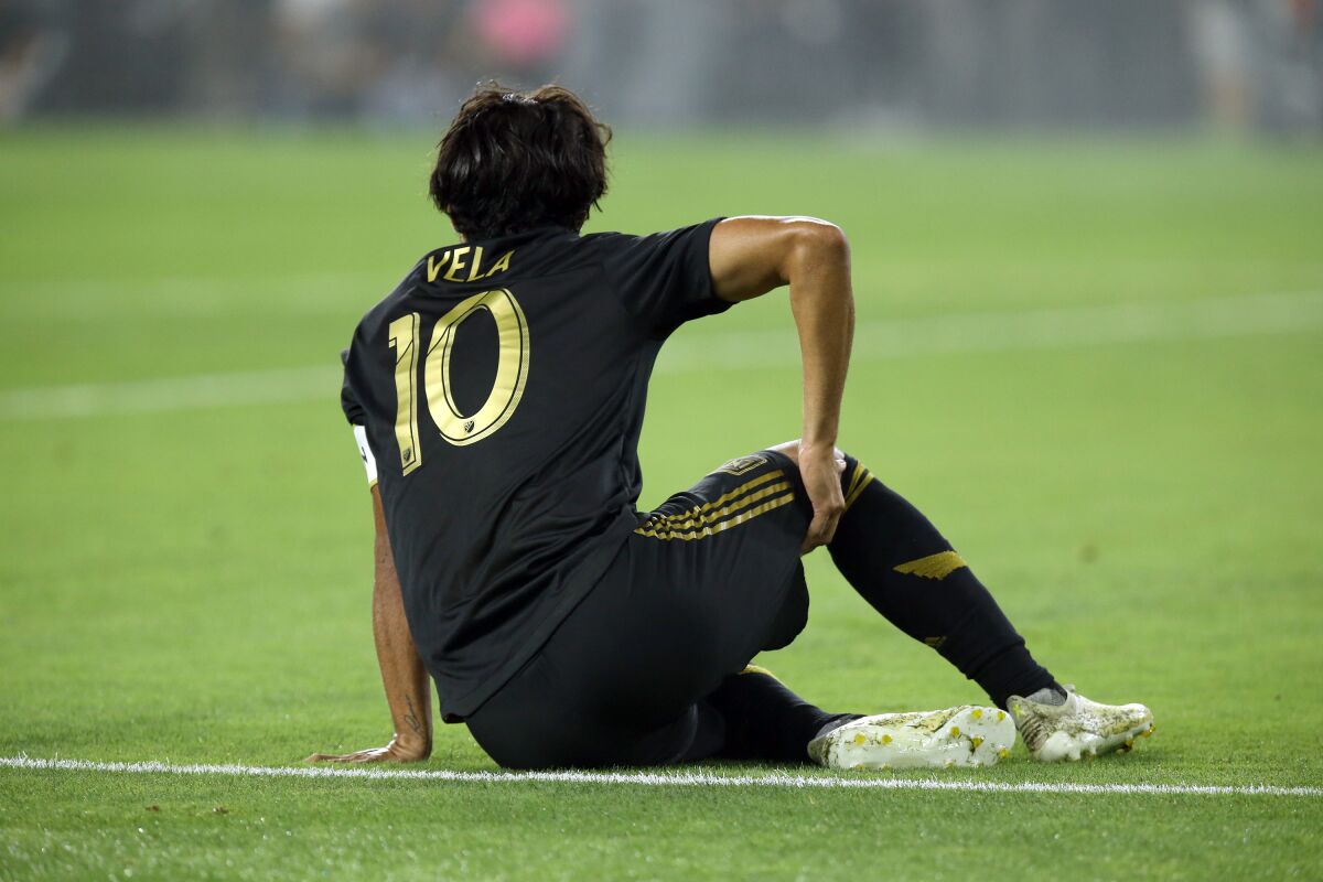 LAFC forward Carlos Vela holds his hamstring shortly after scoring a second half goal against the Galaxy.