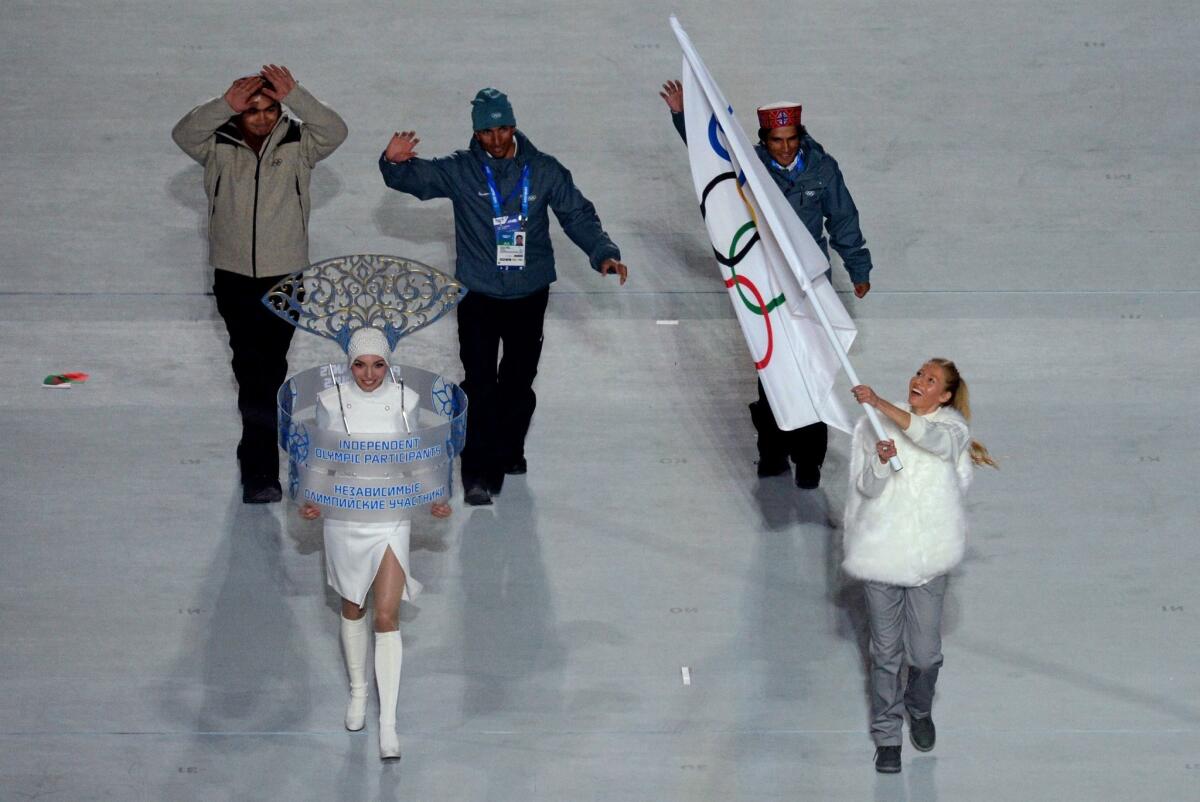 India's three athletes -- luger Shiva Keshavan, left, cross country skier Nadeem Iqbal and alpine skier Himanshu Thakur -- march in Friday's opening ceremony under the Olympic flag. The International Olympic Committee on Tuesday reinstated India, allowing its athletes to compete under their own flag.
