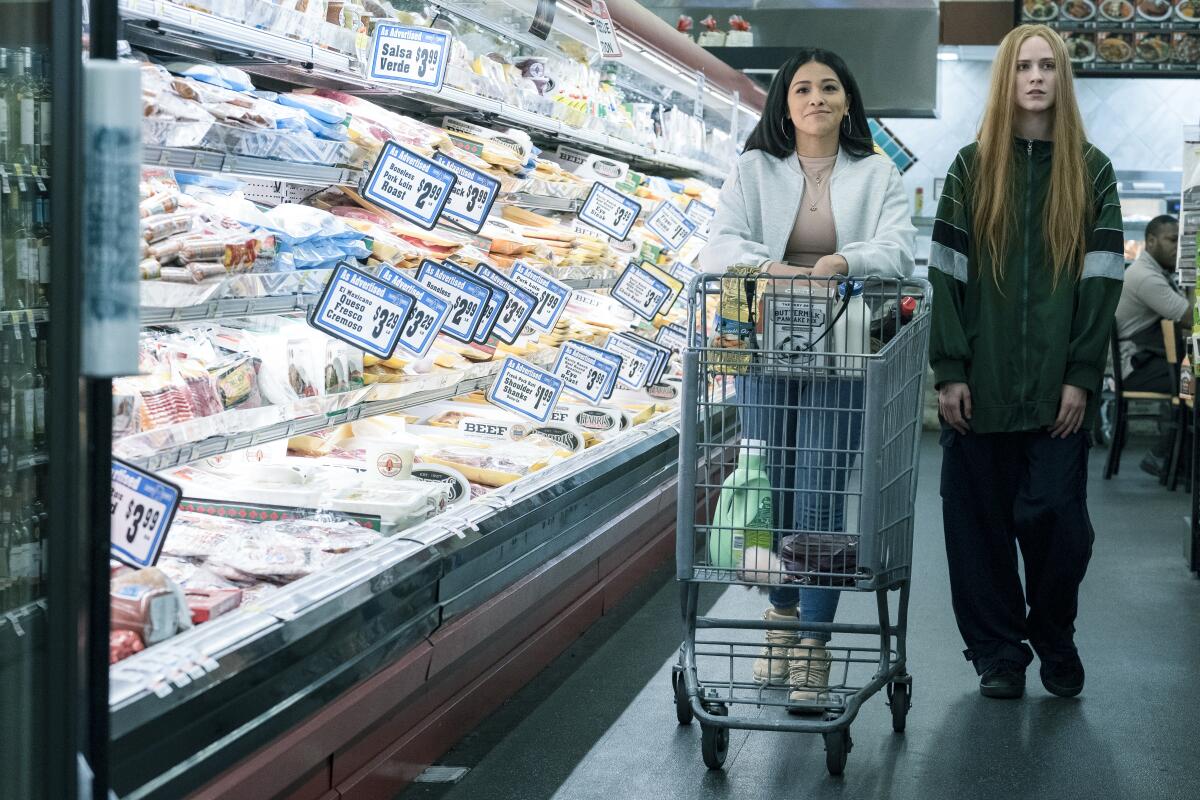 Gina Rodriguez and Evan Rachel Wood walk a supermarket aisle in Miranda July's "Kajillionaire."