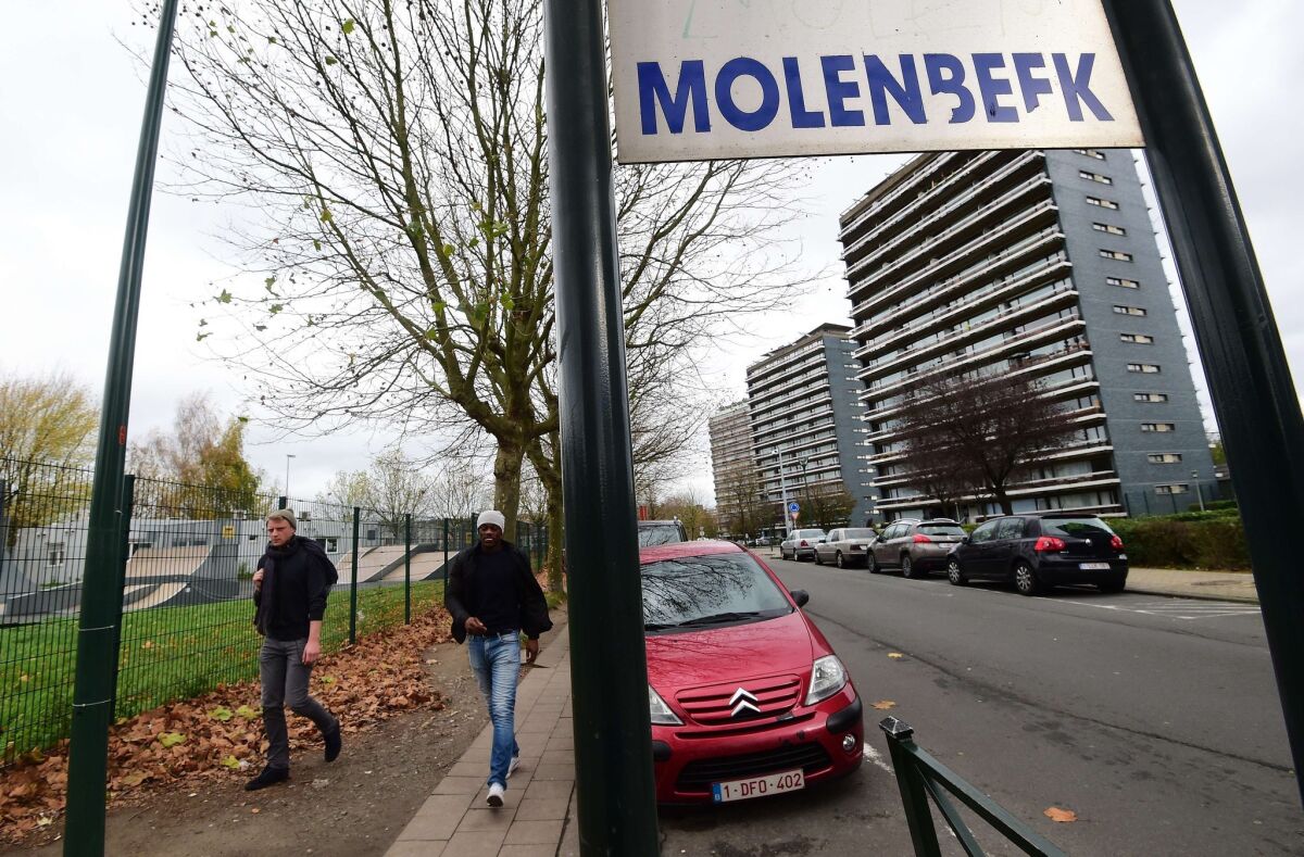 People make their way in Brussels' Molenbeek suburb, near where police made arrests Nov. 15 in connection with the deadly attacks in Paris.