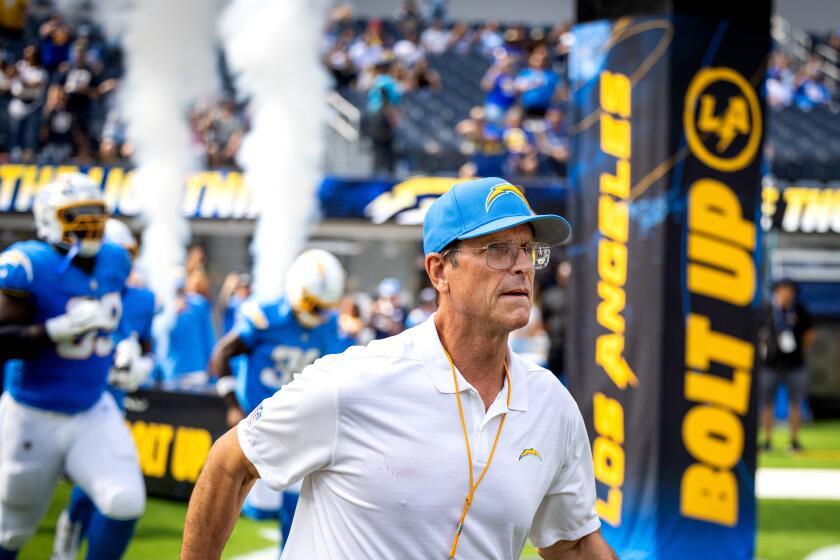 Coach Jim Harbaugh leads his Chargers onto the field.