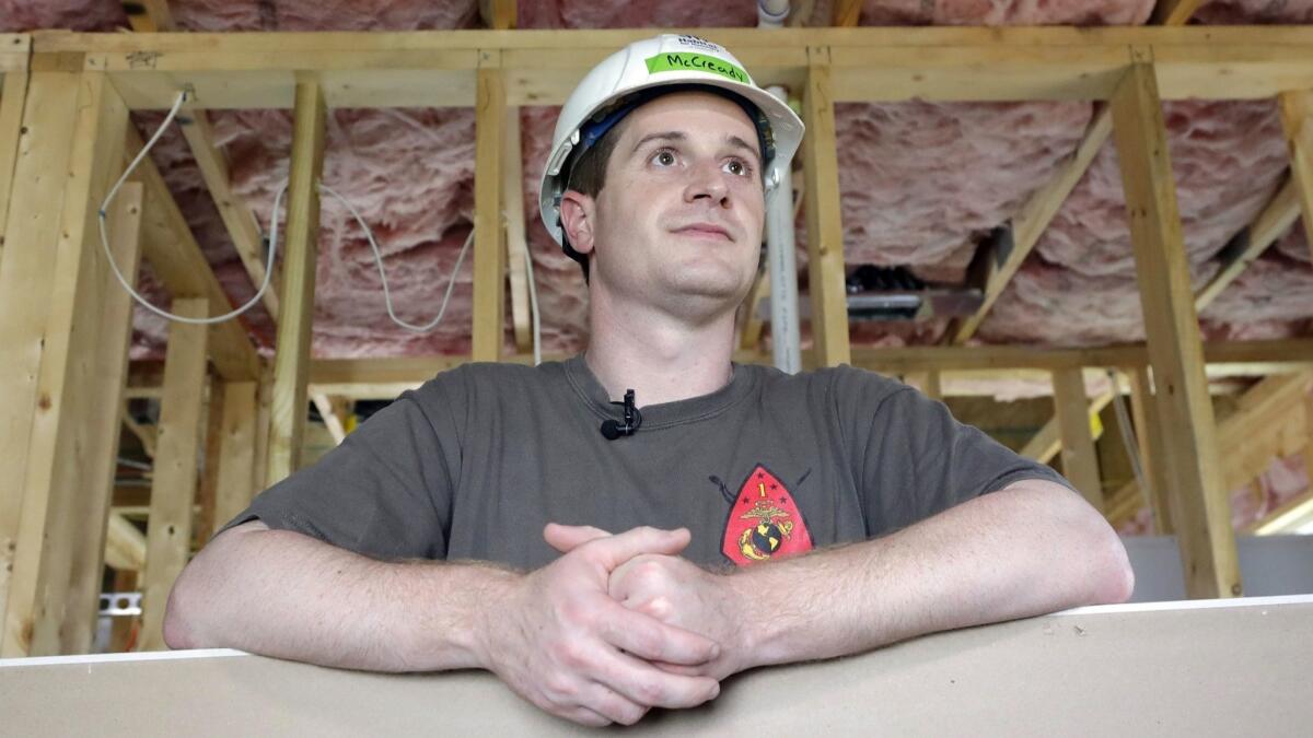Democratic congressional candidate Dan McCready leans against drywall as he pauses during a Habitat For Humanity building event in Charlotte, N.C.