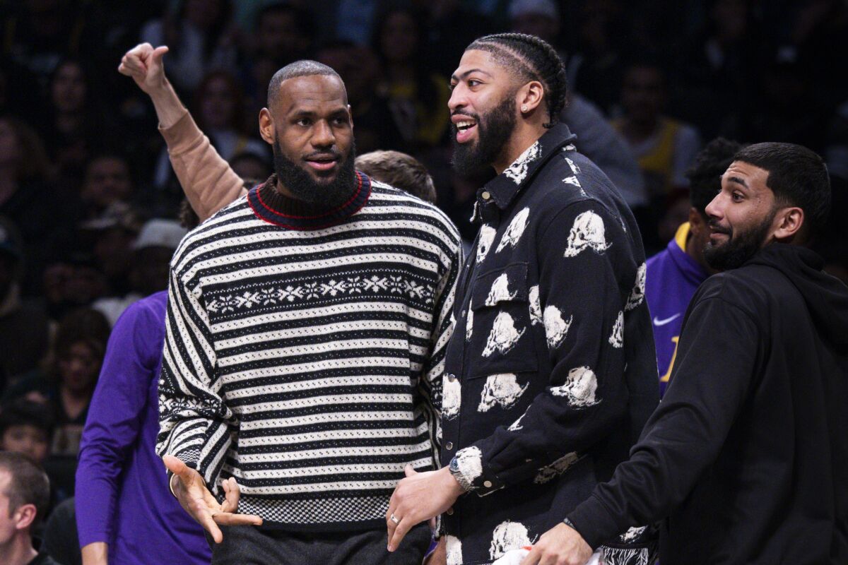 Lakers forwards LeBron James, left, and Anthony Davis look on from the bench.