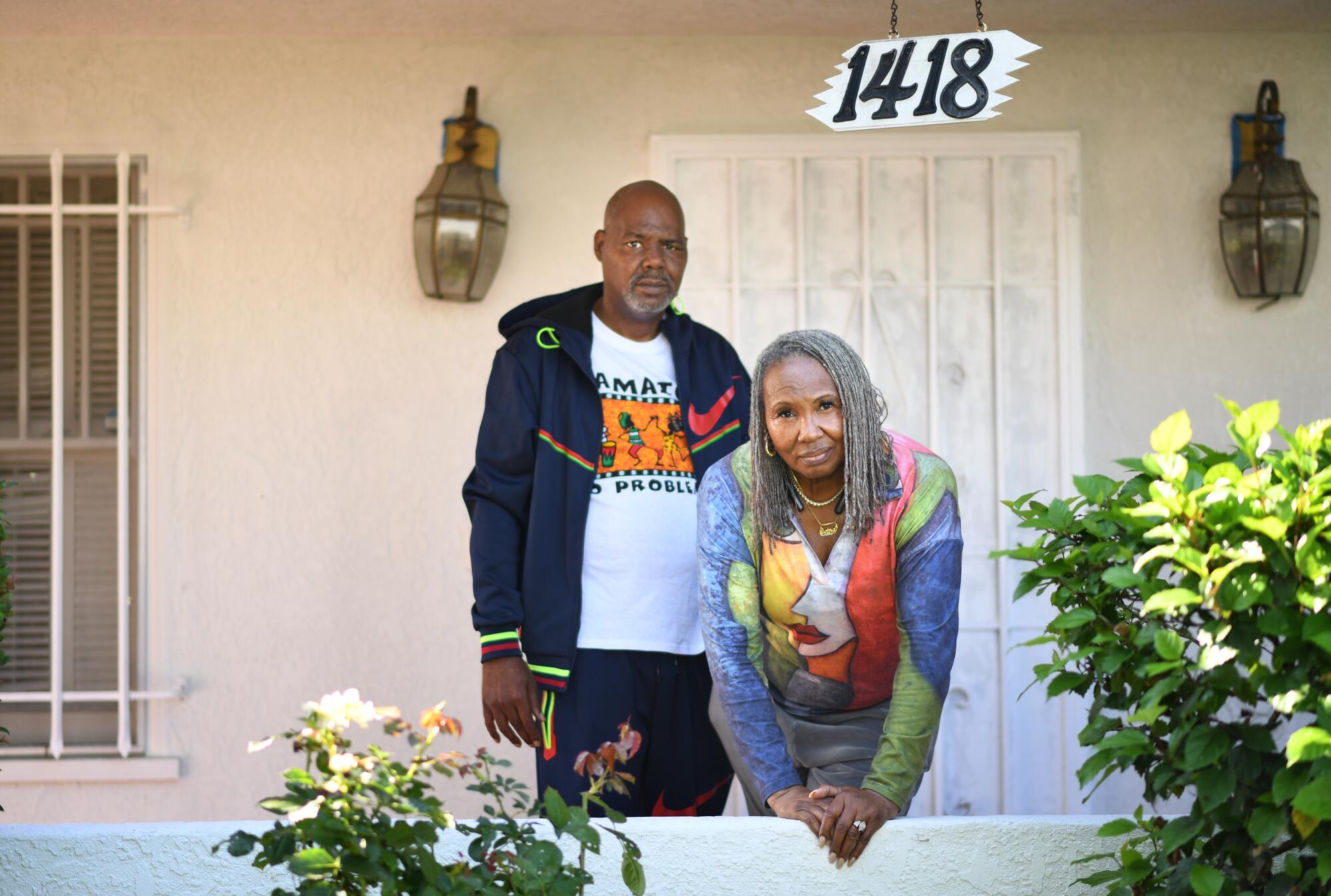 A man and a woman stand outside their home in Los Angeles.