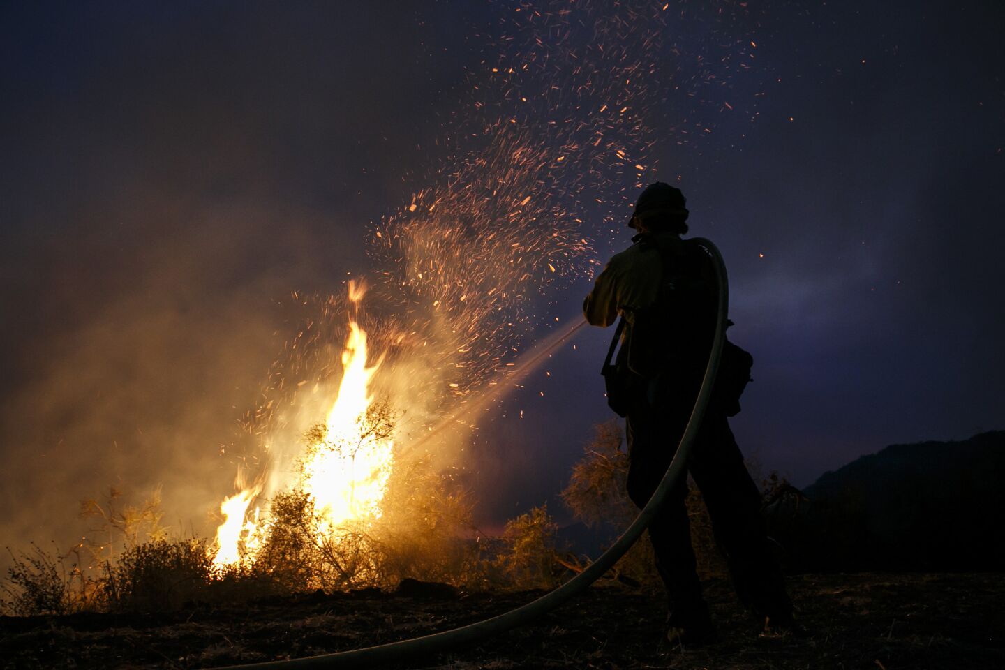 A firefighter tries to control a growing flame in El Capitan Canyon.