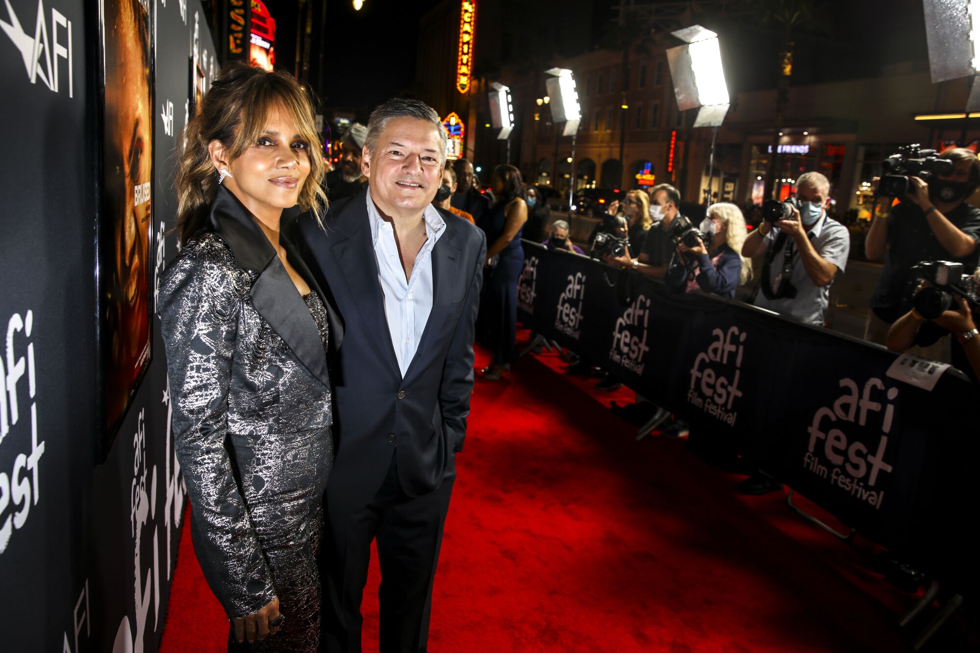 Halle Berry and Ted Serandos on the red carpet with photographers in the background