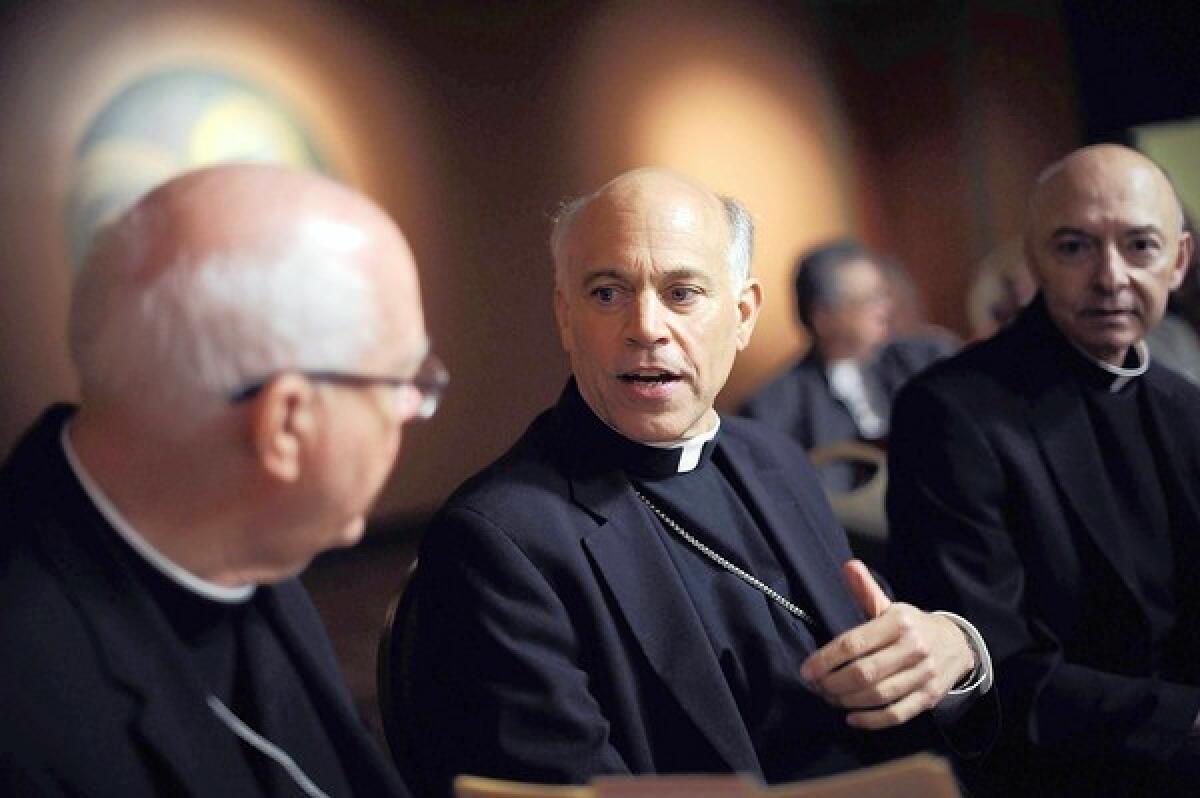 Archbishop Salvatore Cordileone, center, speaks with other clergy members