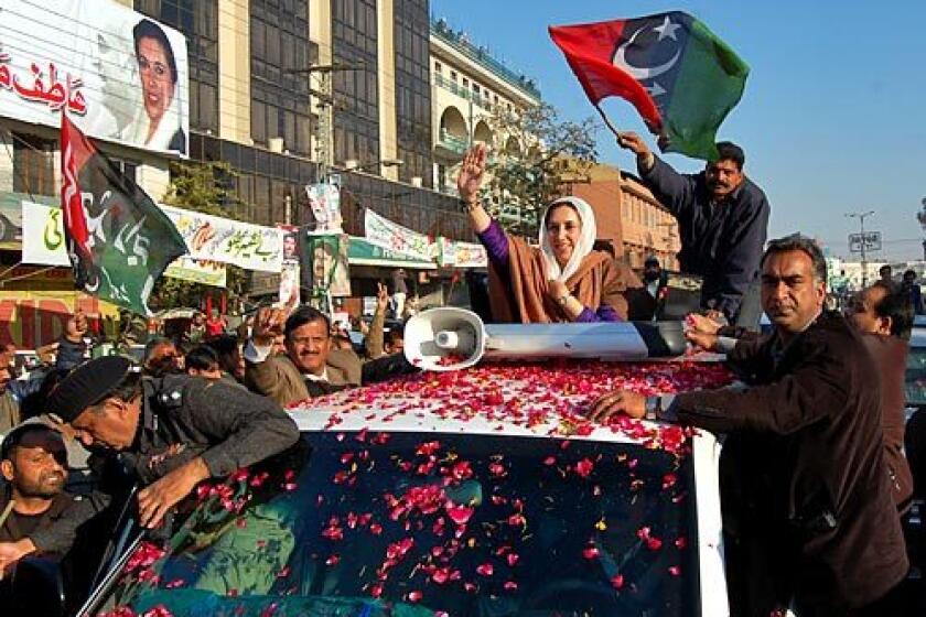 Former Pakistani Prime Minister Benazir Bhutto waves as she arrives in Rawalpindi to address her last public rally. She was assassinated just after the rally ended.