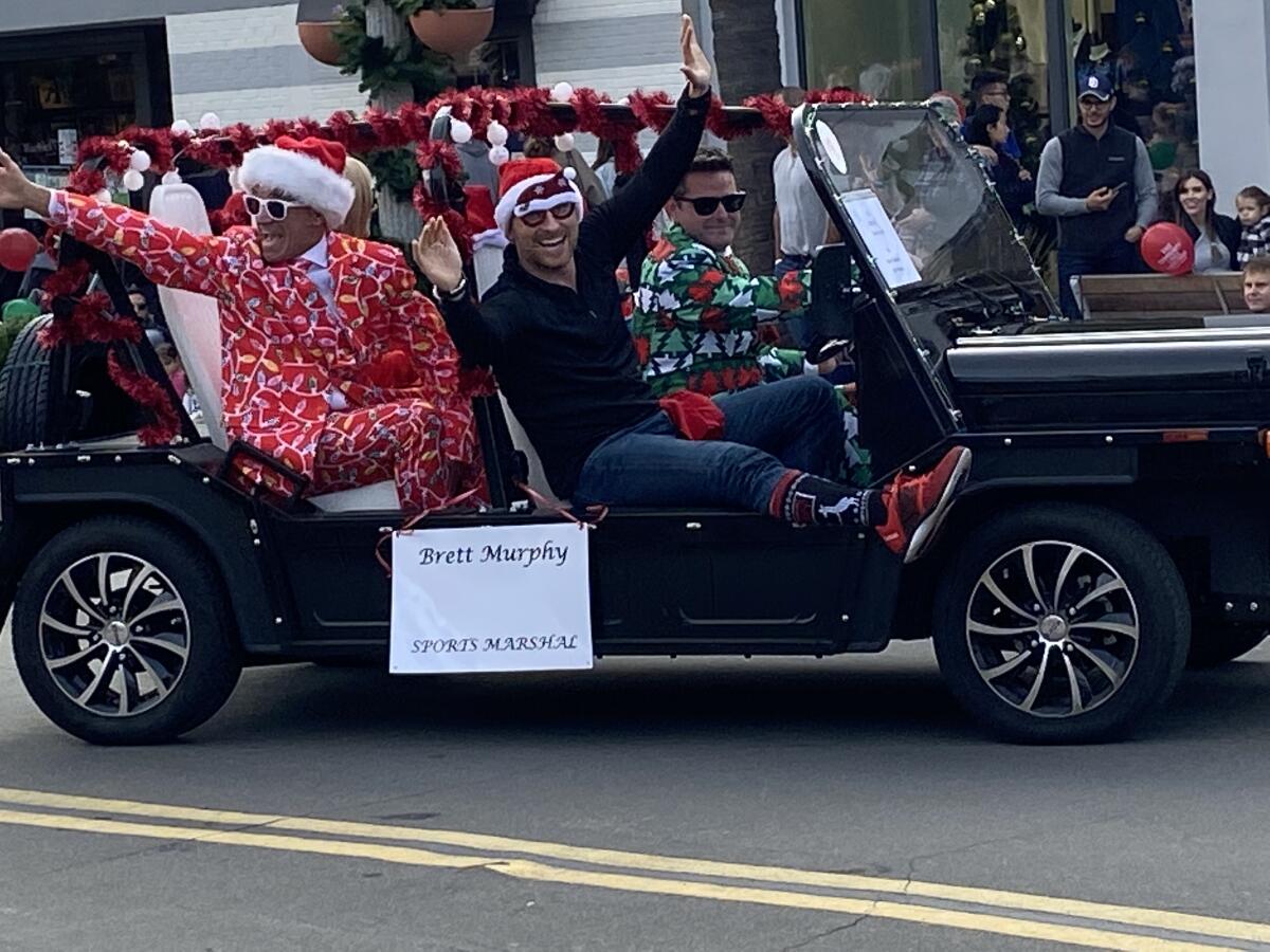 La Jolla Sports Club co-owner Brett Murphy, the parade’s sports marshal, spreads Christmas cheer in a Moke with some friends in colorful attire.