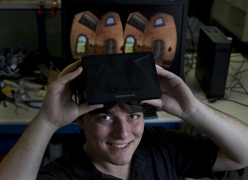 Palmer Luckey, 20, founder, shown at his Irvine office, Oculus Inc., holds a new virtual reality machine he created called Oculus Rift, an upcoming low-latency, high field of view, consumer-priced virtual reality head-mounted display.