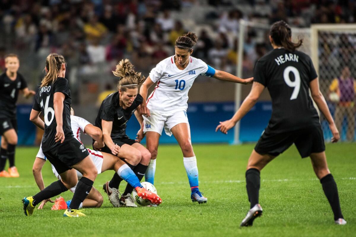 Carli Lloyd (10) of the U.S. vies for the ball with New Zealand's Rebekah Stott.