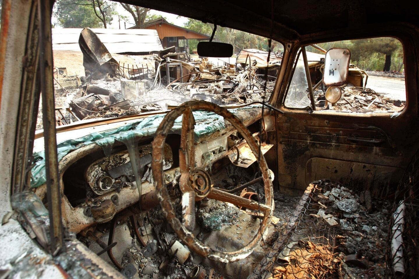 The charred interior of a truck can be seen, along with a storage structure that was burned to the ground by the Powerhouse fire in Lake Hughes.
