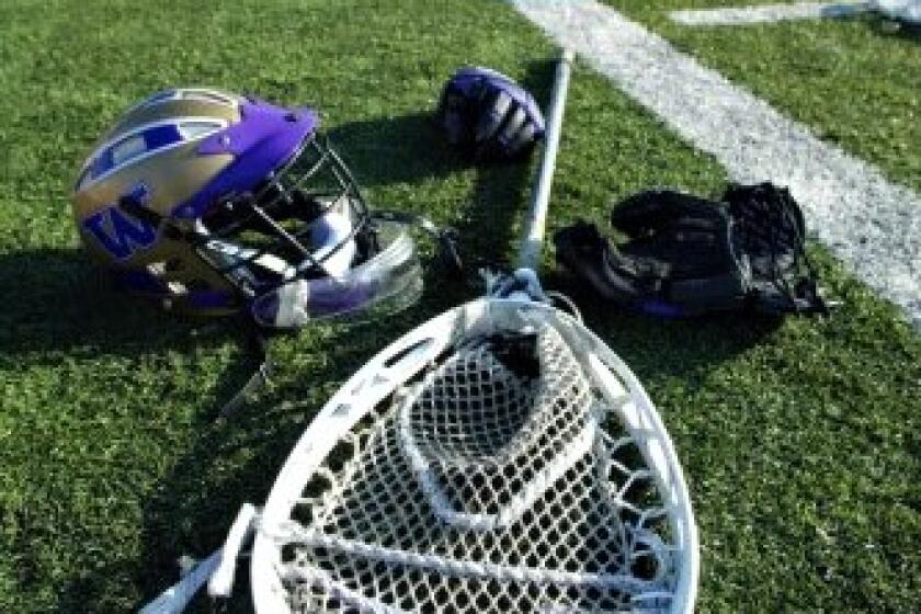 Lacrosse equipment on the sideline of a field.