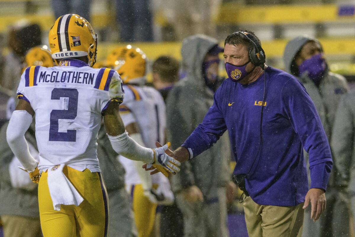 LSU cornerback Dwight McGlothern celebrates a play with head coach Ed Orgeron against Mississippi.