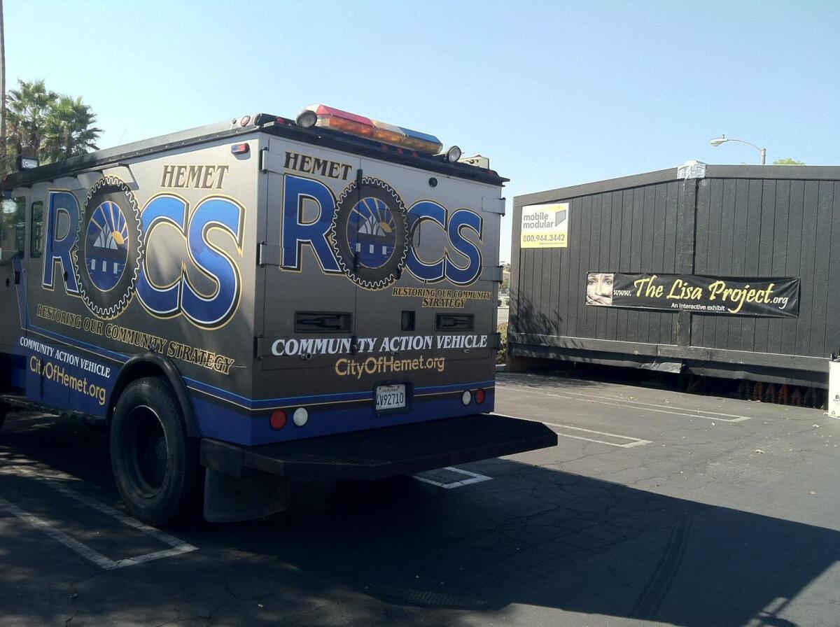 A truck signed "COMMUNITY ACTION VEHICLE" sits in a parking lot