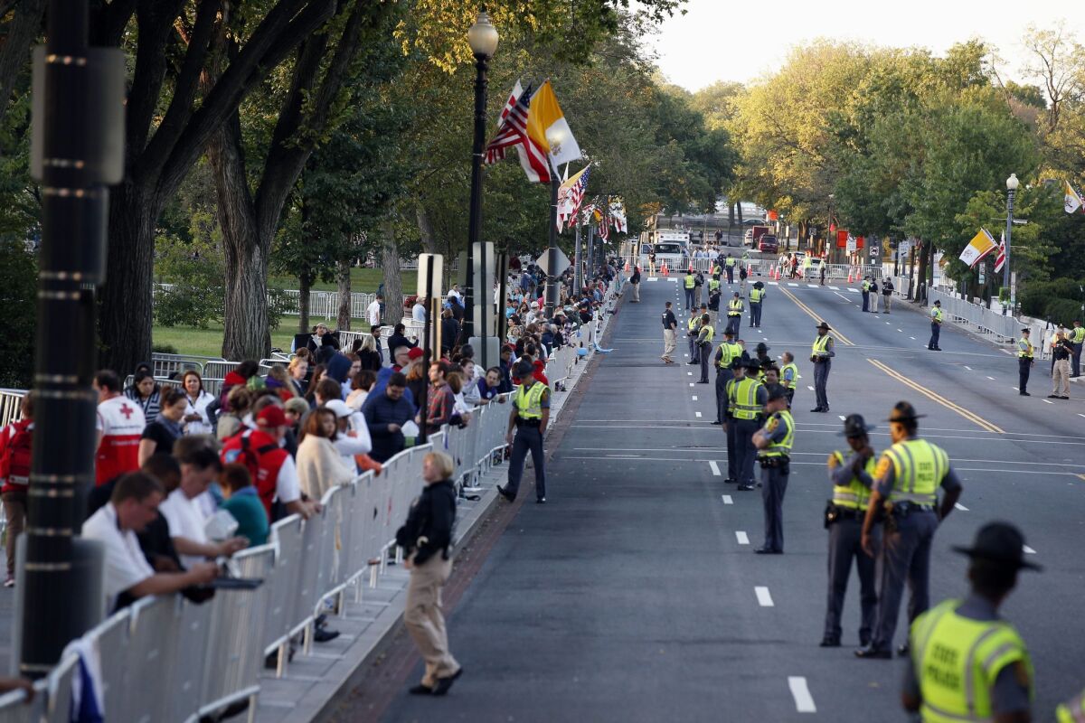 People and security line the parade route on 17th Street looking toward Constitution Avenue for Pope Francis on Wednesday morning in Washington. The parade will take place after President Barack Obama welcomes him at the White House. (AP Photo/Alex Brandon, Pool)