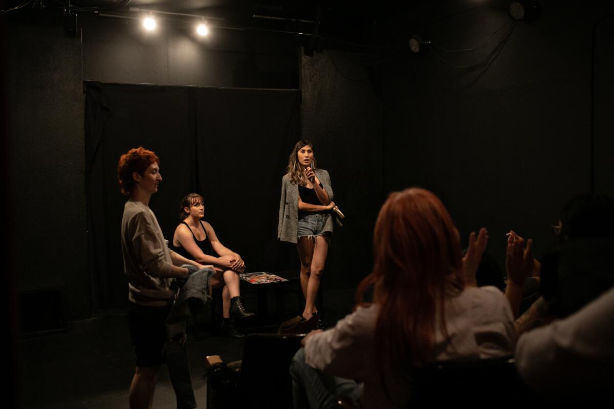 A woman talks to three other people on a stage.