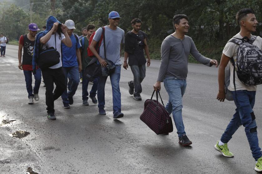 U.S.-bound migrants walk along the roadside as they leave Cofradia, Honduras, early Tuesday, Jan. 15, 2019. Yet another caravan of Central American migrants set out overnight from Honduras, seeking to reach the U.S. border following the same route followed by thousands on at least three caravans last year. (AP Photo/Delmer Martinez)