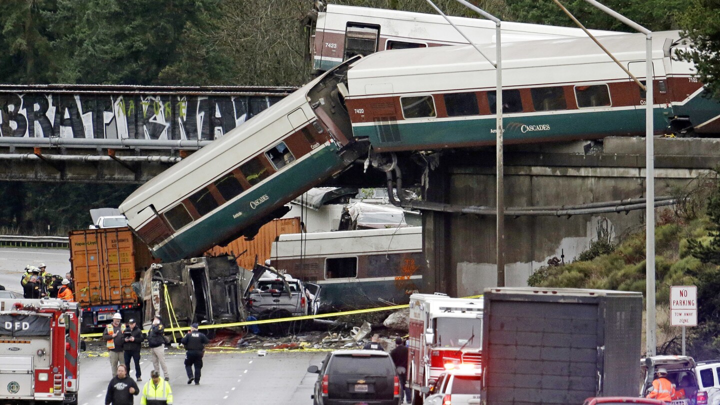Cars from an Amtrak train lay spilled onto Interstate 5 below alongside smashed vehicles as some train cars remain on the tracks in DuPont, Wash.