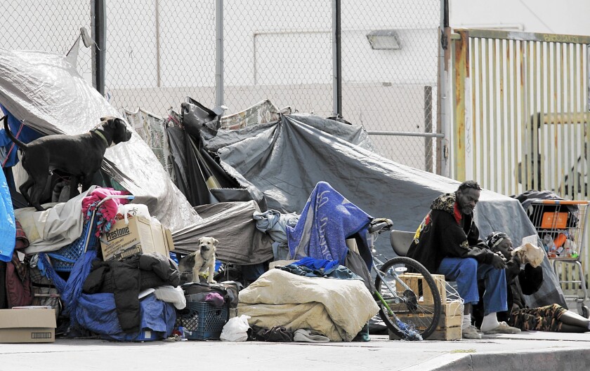Homeless people and their dogs set up camp along Florence Avenue in L.A.'s skid row.