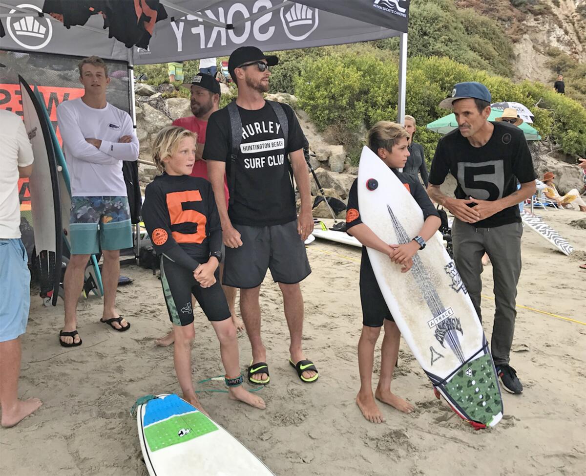 Casey Wheat, far right, and Brett Simpson, center with black T-shirt, offer advice to young surfers during a 2017 West Coast Board Riders Club contest at Salt Creek in Dana Point.