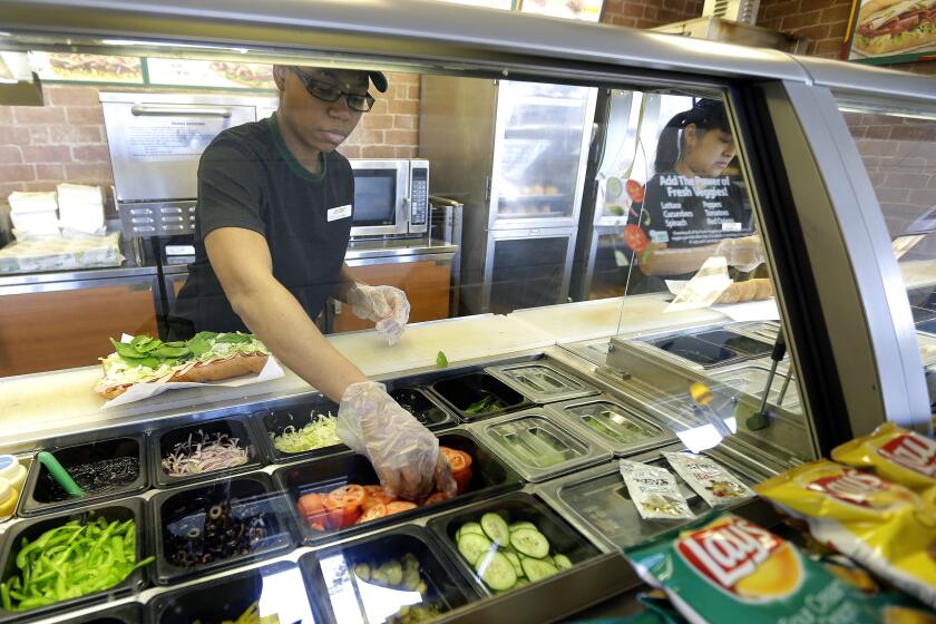 FILE - In this March 3, 2015, file photo, workers make sandwiches at a Subway sandwich franchise in Seattle. Subway promises to ensure its "Footlong" sandwiches measure up to settle a class-action lawsuit. The suit was sparked after a teenager posted a photo on Facebook showing his sandwich was only 11 inches. In October 2015, Subway’s parent company, Doctors Associates, agreed to a preliminary settlement, which was granted final approval on Feb. 25, 2016. (AP Photo/Ted S. Warren, File)