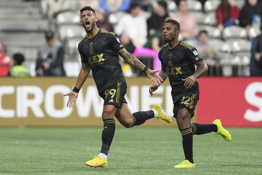 Los Angeles FC's Denis Bouanga, left, and Diego Palacios celebrate Bouanga's first goal against the Vancouver Whitecaps, during the second half of a CONCACAF Champions League soccer match Wednesday, April 5, 2023, in Vancouver, British Columbia. (Darryl Dyck/The Canadian Press via AP)