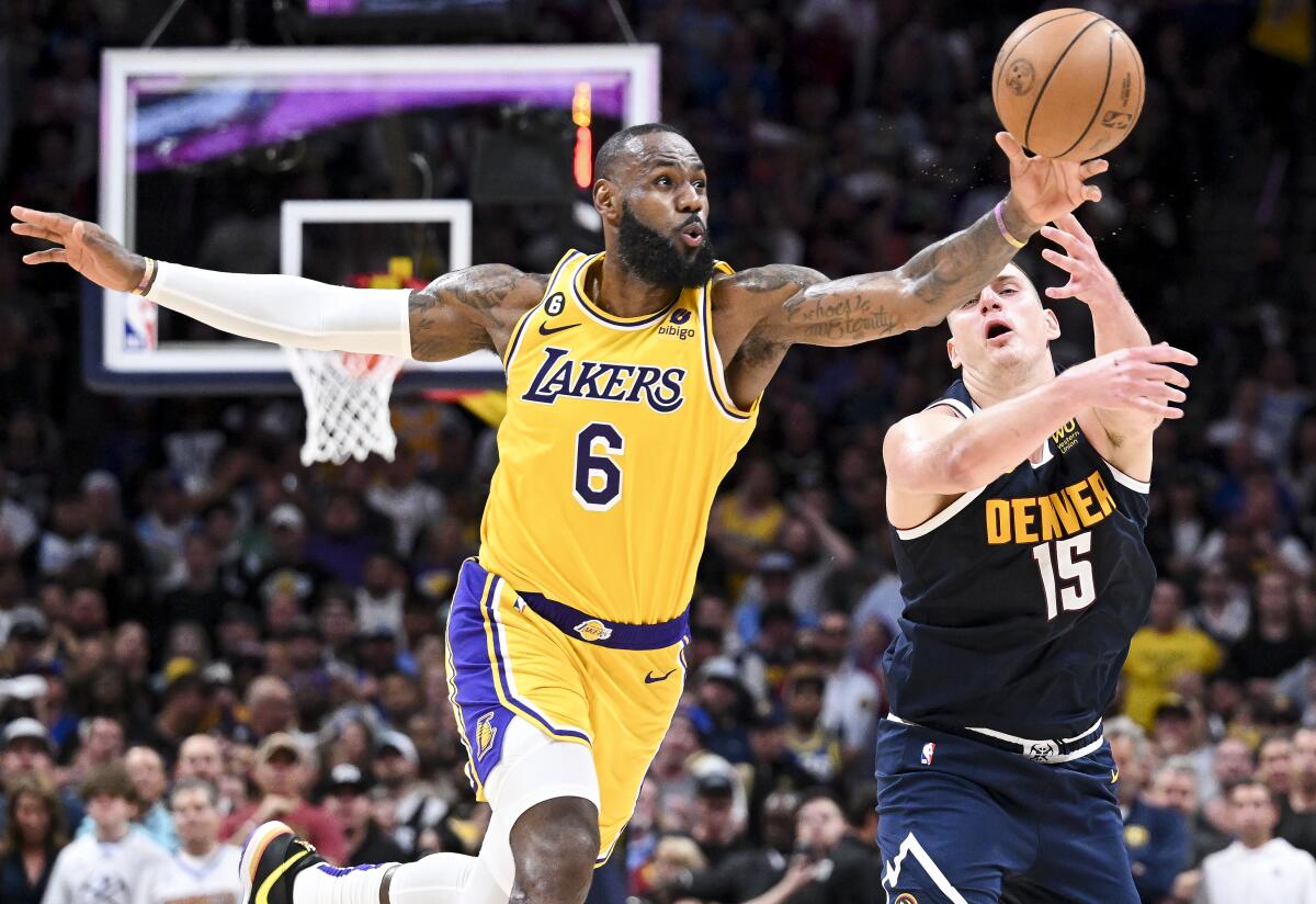 Lakers forward LeBron James, left, steals a pass intended for Nuggets center Nikola Jokic.
