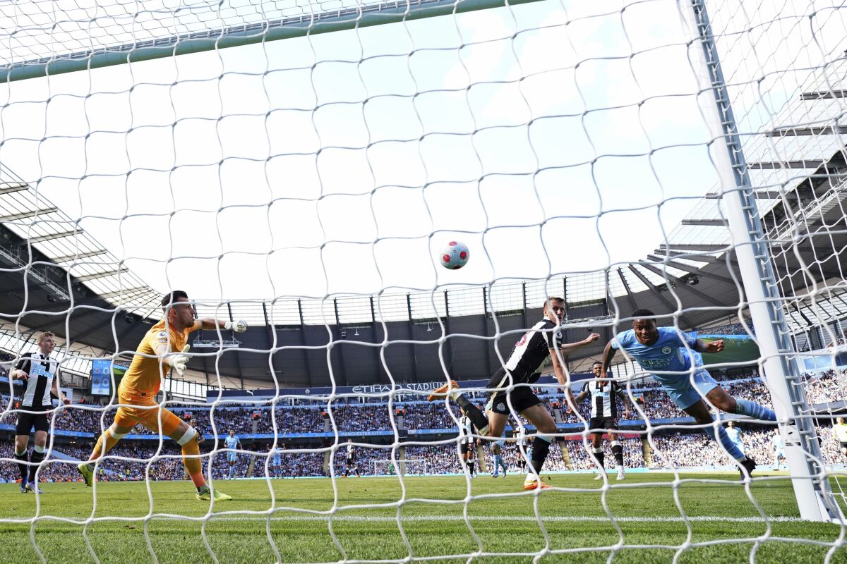 Manchester City's Raheem Sterling, right, heads to score his side's first goal during the English Premier League soccer match between Manchester City and Newcastle United at Etihad stadium in Manchester, England, Sunday, May 8, 2022. (AP Photo/Jon Super)